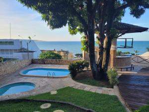a backyard with a swimming pool and a tree at Cobertura exclusiva em ponta negra com vista para o mar in Natal