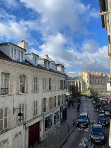 a city street with cars parked next to buildings at Appartement haut de gamme in Saint-Germain-en-Laye