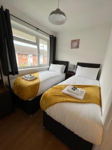 twee bedden in een kamer met een raam bij St Denys 2 bedroom flat, Convenient location next to station, Great for contractors in Southampton