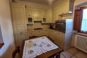 a kitchen with white cabinets and a wooden table at Cuore di Toscana in Pistoia