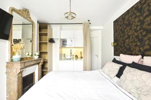 um quarto com uma cama com lareira e um espelho em PL2 - Stunning architect studio near Le Marais em Paris