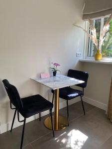 un tavolo con due sedie e un tavolo con fiori di Noflik Heerenveen a Heerenveen