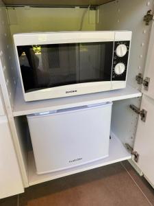 a microwave sitting on top of a shelf at Noflik Heerenveen in Heerenveen