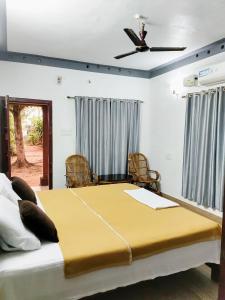 a bedroom with a large bed with a ceiling fan at Beach Island Villas in Kollam