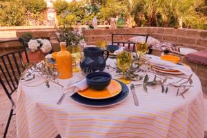 un tavolo con una tovaglia a righe, piatti e bicchieri da vino di Tratturo dei Greci, biocasa vacanza a Lesina