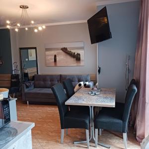 a living room with a table and a couch at Apartament na nowej starówce in Kołobrzeg