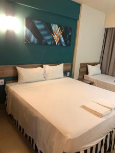 una camera da letto con un grande letto bianco in una stanza di Solar das Aguas Resort - Olímpia a Olímpia