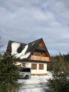 una casa con una camioneta estacionada enfrente en Zaśnieżony Domek przy Dolinie Chochołowskiej, en Witów