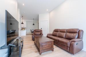 a living room with a couch and a tv at Room 1 of Lovely Montgomery Home, downtown Calgary in Calgary