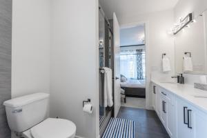 a white bathroom with a toilet and a sink at Room 1 of Lovely Montgomery Home, downtown Calgary in Calgary