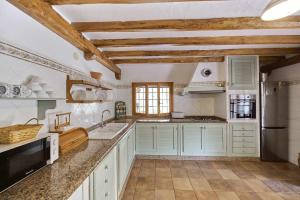 a kitchen with white cabinets and a counter top at Can Valencià in Montecristo