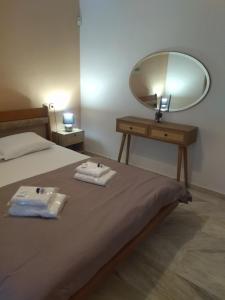 una camera da letto con un letto con uno specchio e due asciugamani di Άνετο εξοχικό με ιδιωτικό χώρο στάθμευσης 