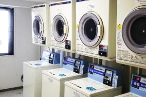 a laundry room with four washing machines on display at Country Hotel Niigata in Niigata