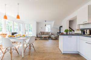 a kitchen and living room with a table and chairs at Bornhaus für 7 Personen in Born