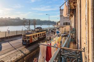 un autobús escolar conduciendo por una calle al lado de un edificio en Happy Porto Hostel & Apartments, en Oporto