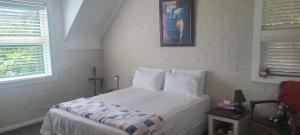 une chambre avec un lit avec des draps blancs et des oreillers dans l'établissement Hout Bay Sea View, au Cap 23 autres photos