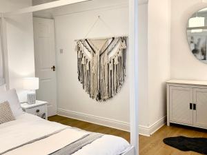 a bedroom with a harp hanging on the wall at Windsor Cottage in Amble