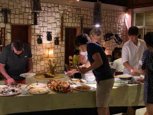 a group of people standing around a table with food at Laguna Blu - Resort Madagascar in Andavadoaka