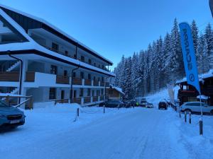 a snow covered street in front of a hotel at APARTMÁNY BIELA PÚŤ - Chopok SKI - Jasná in Belá