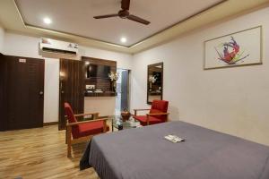 Habitación con cama, mesa y sillas. en Van Vihar Resort, en Sasan Gir