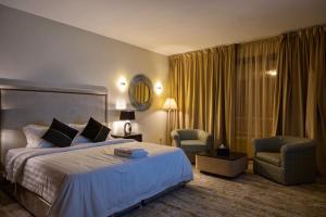 巴里朱拉希的住宿－Ghodran Hotel and Resort，酒店客房,配有一张床和两把椅子