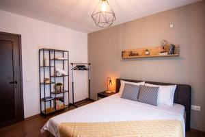 um quarto com uma grande cama branca e uma prateleira em Apartment with private parking 2 em Sófia