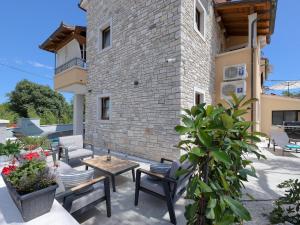 a patio with a table and chairs and a building at Lovely villa with swimming pool and terrace in Hreljići