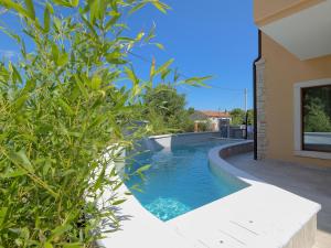 a swimming pool next to a house at Lovely villa with swimming pool and terrace in Hreljići