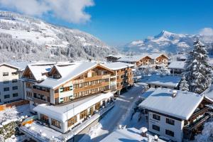 - une vue aérienne sur un complexe avec des bâtiments recouverts de neige dans l'établissement Alpen Glück Hotel Kirchberger Hof, à Kirchberg in Tirol