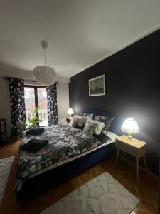 a bedroom with a bed and a table with a lamp at Jordan Apartman in Niška Banja
