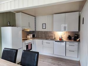 a kitchen with white cabinets and a table and chairs at Visit Undredal in Undredal