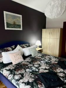 a bedroom with a bed with a floral comforter at Jordan Apartman in Niška Banja