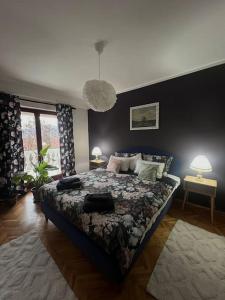 a bedroom with a bed and two tables with lamps at Jordan Apartman in Niška Banja