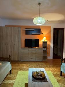 a living room with a television and a cake on a table at Jordan Apartman in Niška Banja