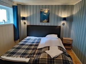 a bedroom with a bed with a plaid blanket at Visit Undredal in Undredal