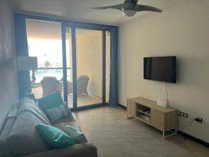 uma sala de estar com um sofá e uma televisão de ecrã plano em Casa Teri - La Concha em Cotillo
