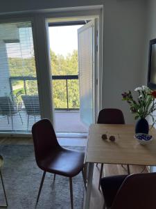 ein Wohnzimmer mit einem Tisch, Stühlen und einem Fenster in der Unterkunft Helsinki Espoo Bright apartment /w big balcony close to Aalto University and metro in Espoo