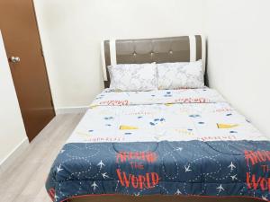 a bedroom with a bed with a comforter on it at UG Homestay BP - Netflix & 4 Air-Con Rooms in Batu Pahat