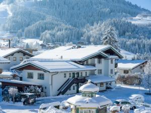 a house covered in snow with snow covered roofs at Alpen Glück Villa Lisa in Kirchberg in Tirol