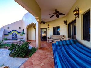 a living room with a ceiling fan and a couch at Casa Roja Rental Home - Taste of San Felipe in Playa Unión