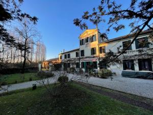 un grande edificio bianco con un cortile davanti di B&B Villa Gradenigo a Lancenigo