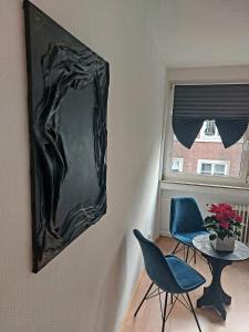 un espejo colgado en una pared junto a una mesa y sillas en Central and calm appartement in Aachen, en Aachen