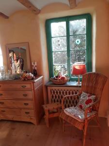 a bedroom with a dresser and a chair and a mirror at Chez Cathy in Arzier