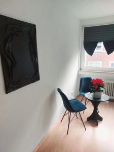 a room with a chair and a table and a window at Central and calm appartement in Aachen in Aachen