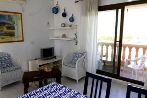 a living room with a bed and chairs and a television at Casa Lago - Formenteralodge in Es Pujols