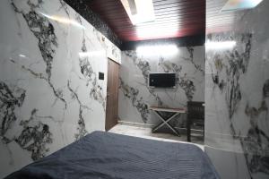 a bedroom with a bed and a tv on a wall at SRS GRAND in Hyderabad