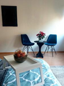 una habitación con 2 sillas y un bol de fruta en una mesa en Central and calm appartement in Aachen, en Aachen