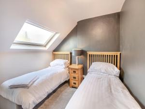 two twin beds in a room with a window at Beaufort Apartment in Tenby