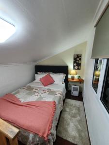 een slaapkamer met een bed met een rode deken bij Casa do Vale Encantado in Furnas