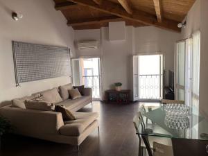 ein Wohnzimmer mit einem Sofa und einem Glastisch in der Unterkunft Elegante torretta in centro in Faenza